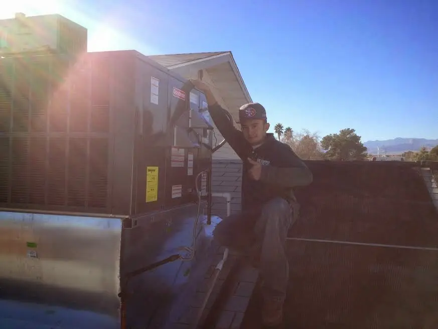 HVAC technician performing HVAC Inspection on a rooftop unit in Naperville